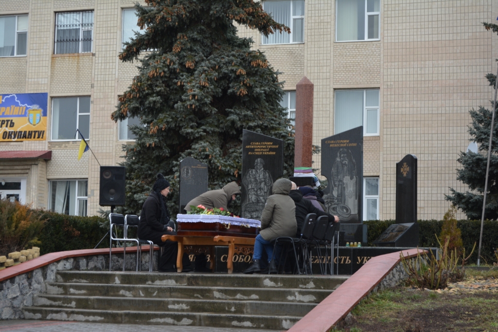 в Томашполі біля пам’ятного знаку «Борцям за Свободу і Незалежність України» рідні Артема Беріла сидять навколо труни із його тілом
